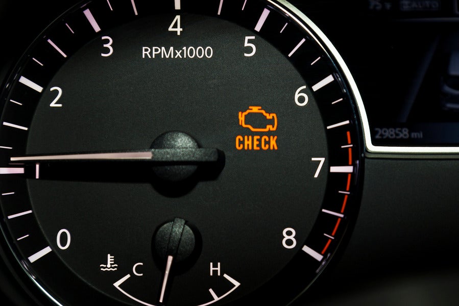 Car dashboard with check engine light illuminated 
